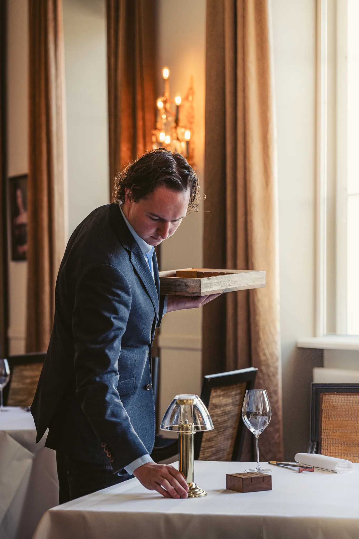 Sommelier van restaurant Karel 5 in Utrecht setting up the table for dinner. in the michelin star restaurant