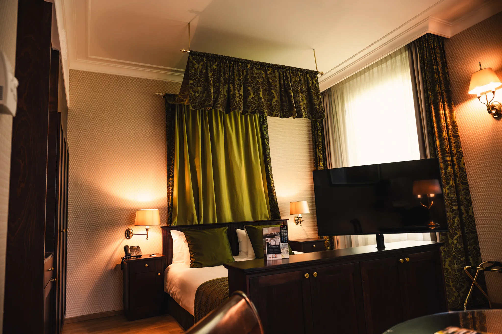Overzicht van het slaapgedeelte in de Luxury Room, met een ruim opgemaakt bed en televisie tegenover het bed, ingericht om na een dag in Utrecht comfortabel tot rust te komen