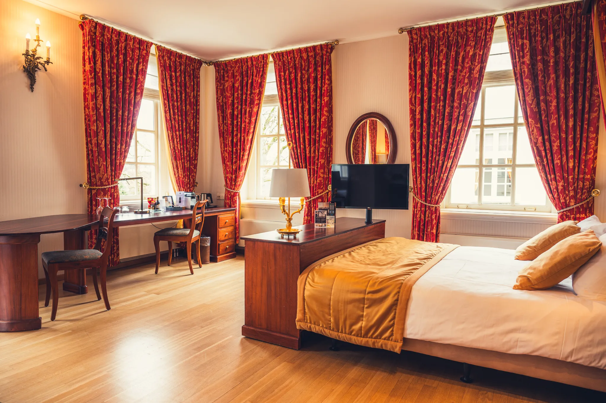 Ruime Empire Executive Triple Kamer van Grand Hotel Karel V met televisie, bureau en comfortabele slaapruimte, ingericht in karakteristieke Empire-stijl voor een verblijf in Utrecht.