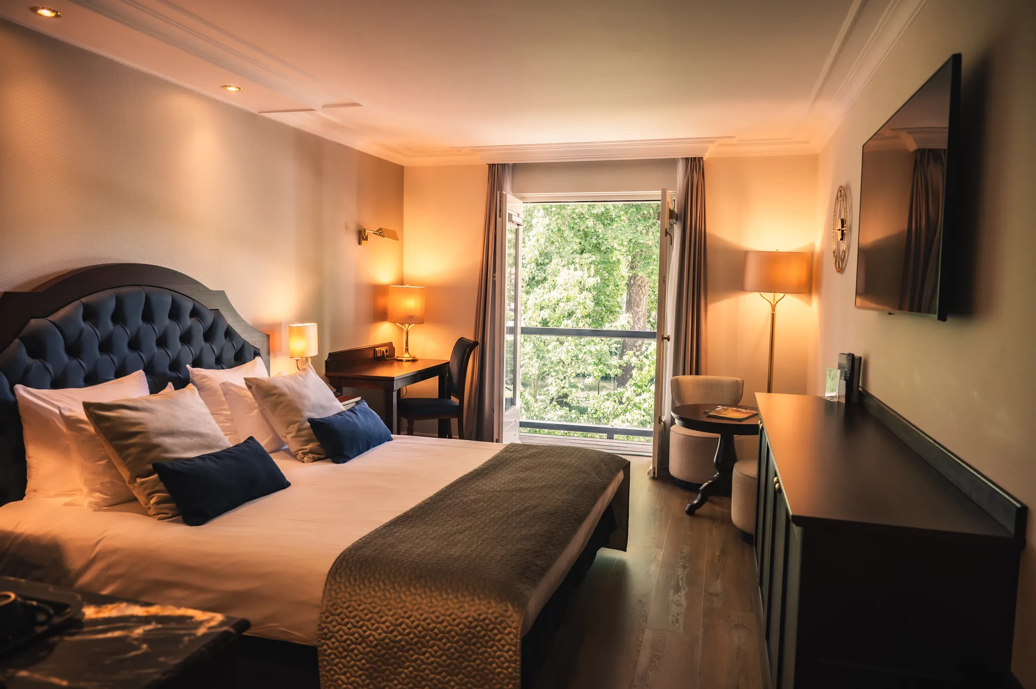 Overzicht van de Comfort Kamer met balkon van Grand Hotel Karel V, met comfortabel bed, zithoek en moderne inrichting in Utrecht.